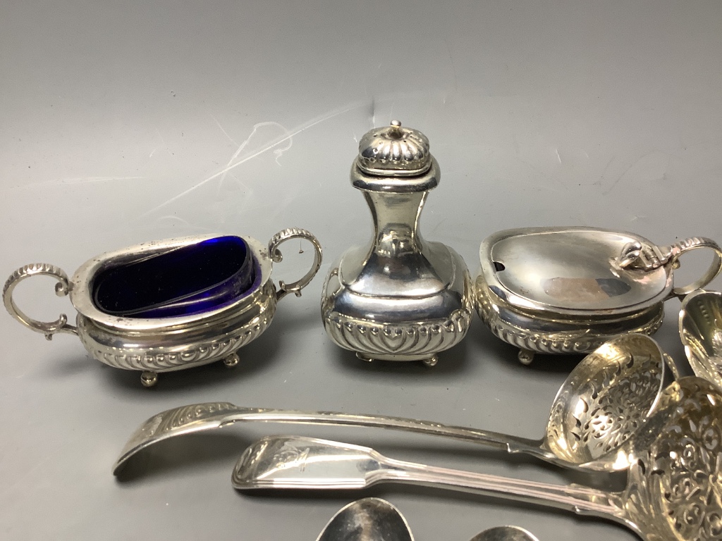 A three-piece silver condiment of oval half-reeded form, two silver sifter spoons, a pair of silver berry spoons and sundry silver flatware, approximately 18oz